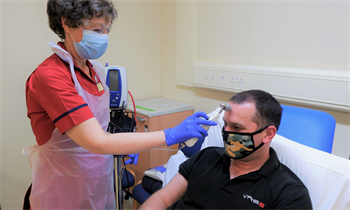 A research nurse taking a patients temperature.