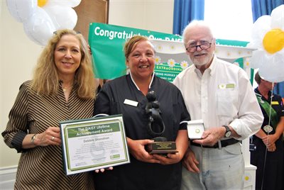 DAISY Foundation founders Mark and Bonnie Barnes present a lifetime achievement award to outgoing Director of Nursing